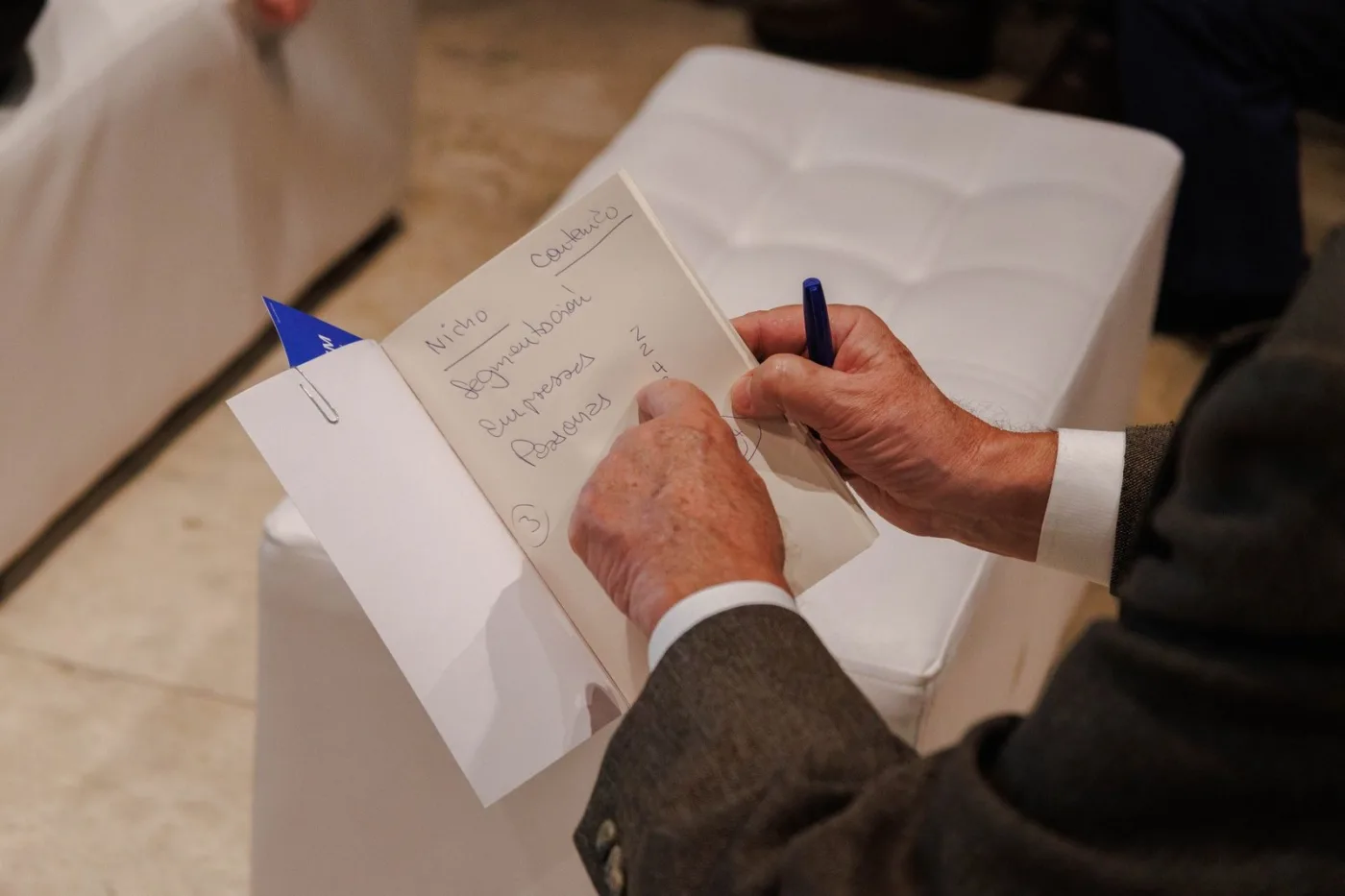 Asistente tomando apuntes del diagnóstico de su marca en una libreta de TOTEM