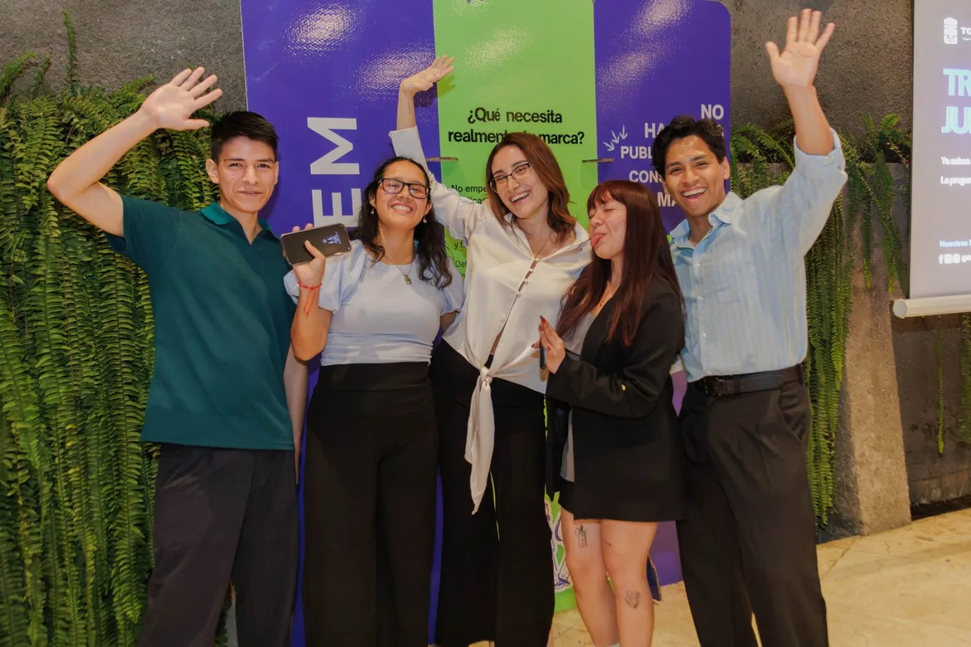 El equipo de TOTEM saludando frente al banner del workshop