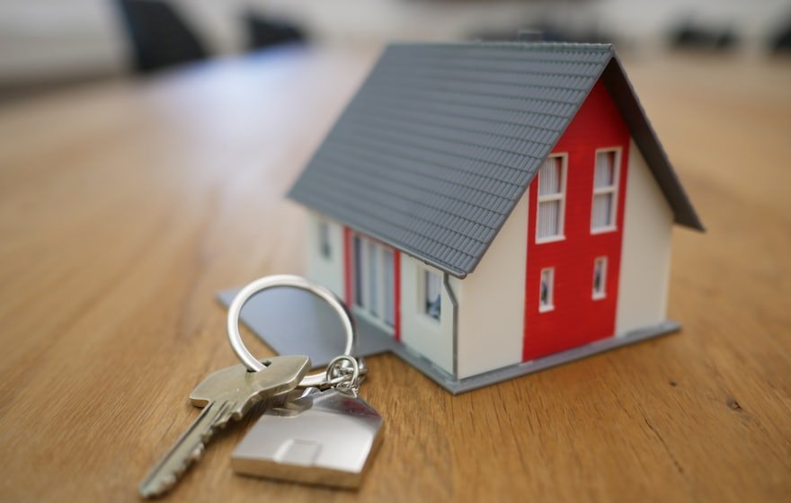 Casa en miniatura con llaves sobre una mesa. Branding para el sector inmobiliario